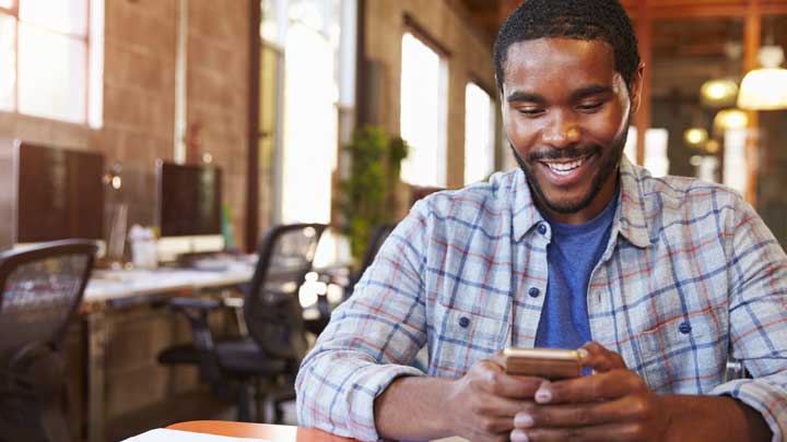 Man smiling using his phone