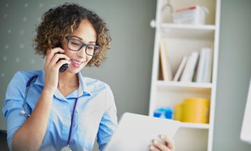 Doctor reviews patient chart in telehealth consultation using tablet