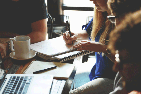 Group of students sitting at a table working on a project